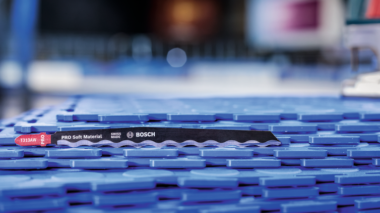 PRO Soft Material T313AW Jigsaw Blade, 152 mm, 3 pcs Saw blade for cutting soft materials placed on a blue plastic surface.