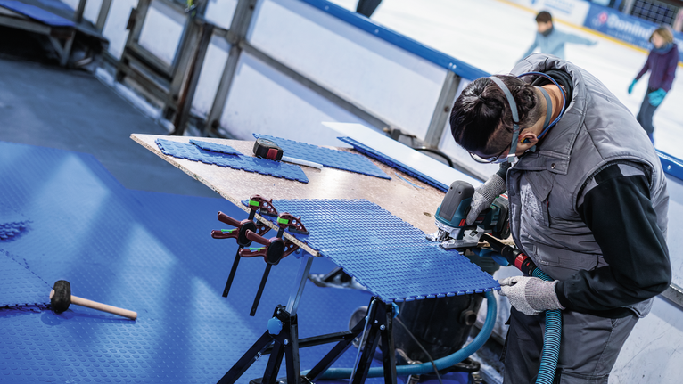 PRO Soft Material T313AW Jigsaw Blade, 152 mm, 3 pcs Person wearing safety equipment cuts blue floor panels with a power tool.