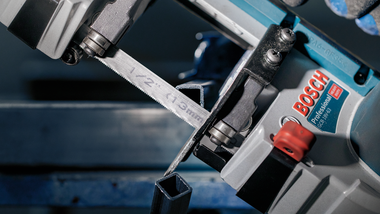 PRO CB4424 Band Saw Blade, 1140 mm, 2 pcs Metal bandsaw cutting a hollow square metal tube in a workshop.