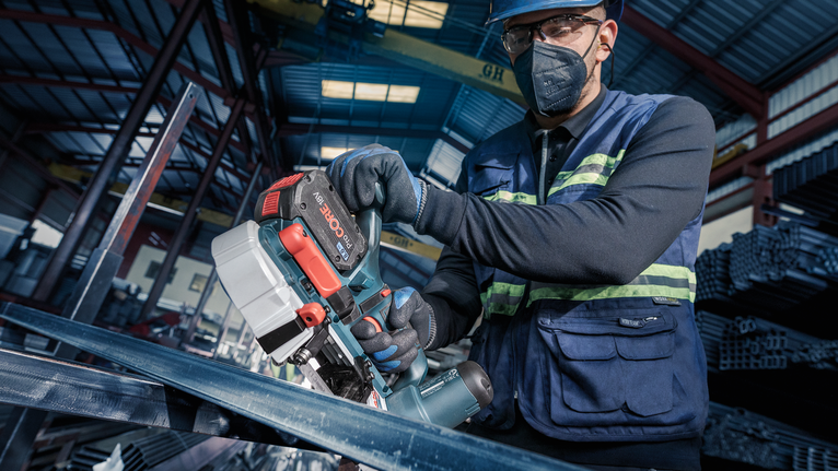 PRO CB4414 Band Saw Blade, 1140 mm, 2 pcs A person wearing safety equipment uses a band saw to cut metal beams.