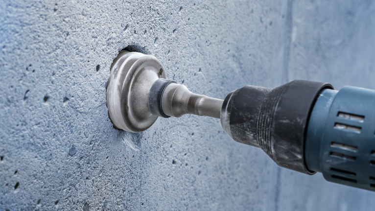 PRO SDS max-5 Core Cutter, 125 x 80 x 97 mm Core drill creating a circular hole in a concrete wall.