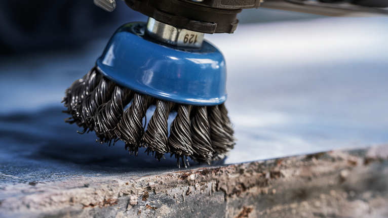 PRO Metal heavy Cup Brush, 75 x 0.5 mm, Thread Steel wire brush attachment polishing a rough metal surface.