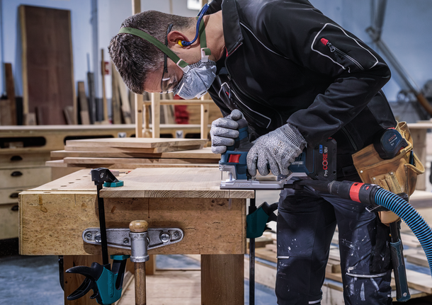 PRO Hardwood clean T101AIF Jigsaw Blade, 100 mm, 5 pcs Person wearing safety equipment uses a power tool to cut wood on a workbench.