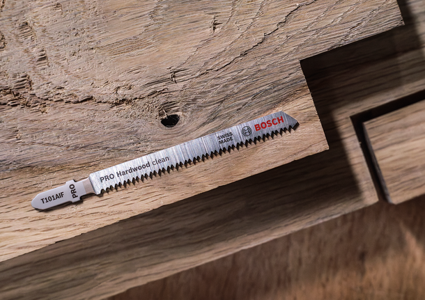 PRO Hardwood clean T101AIF Jigsaw Blade, 100 mm, 5 pcs Jigsaw blade placed on a wooden surface with a cutout section.