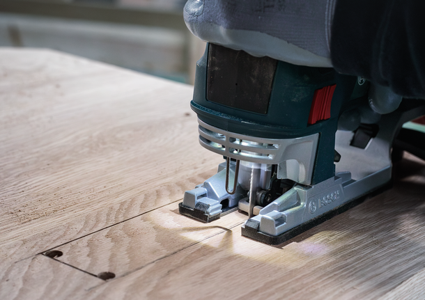 PRO Hardwood clean reverse T101BRF Jigsaw Blade, 100 mm, 5 pcs Person wearing safety equipment uses a jigsaw to cut a rectangular section in wood.