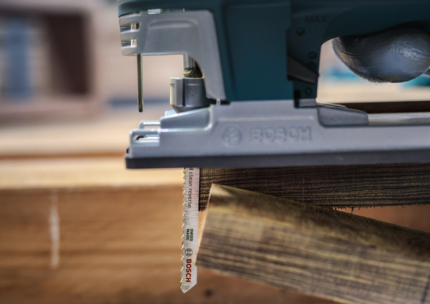 PRO Hardwood clean reverse T101BRF Jigsaw Blade, 100 mm, 5 pcs Person wearing safety equipment uses a jigsaw to cut a wooden plank.