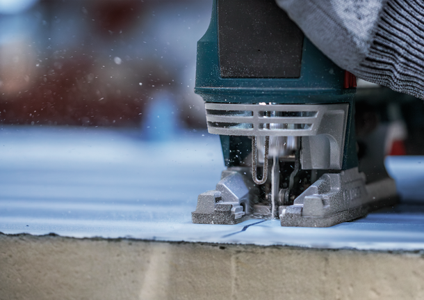 PRO Metal Sandwich T718BF Jigsaw Blade, 180 mm, 3 pcs Person uses a jigsaw to cut along a marked line on a wooden board.