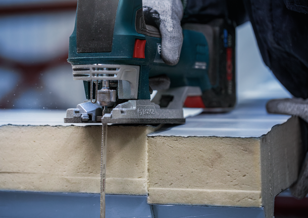 PRO Metal Sandwich T718BF Jigsaw Blade, 180 mm, 3 pcs Person wearing safety equipment cuts insulation board with a jigsaw.