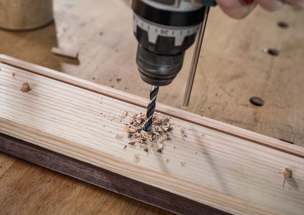 PRO Wood Brad Point Drill Bit Set, 8 pcs Person using a drill to create a hole in a wooden board.