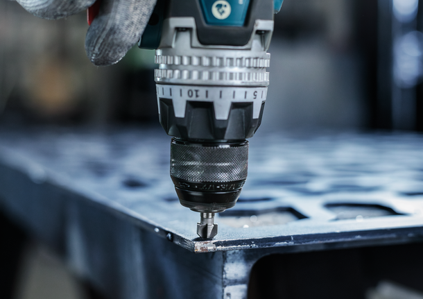PRO Steel HSS Countersink Bit, 12 x 40 mm, M6 Person wearing safety equipment uses a power drill on a metal sheet.