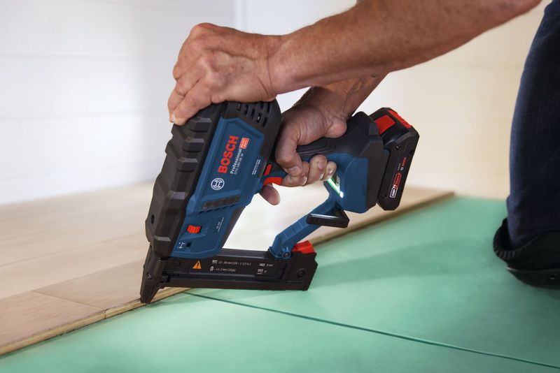 Person uses a cordless narrow crown stapler to fasten flooring.