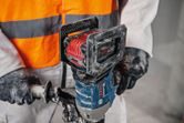 A person wearing safety equipment operates a cordless stirring mechanism.