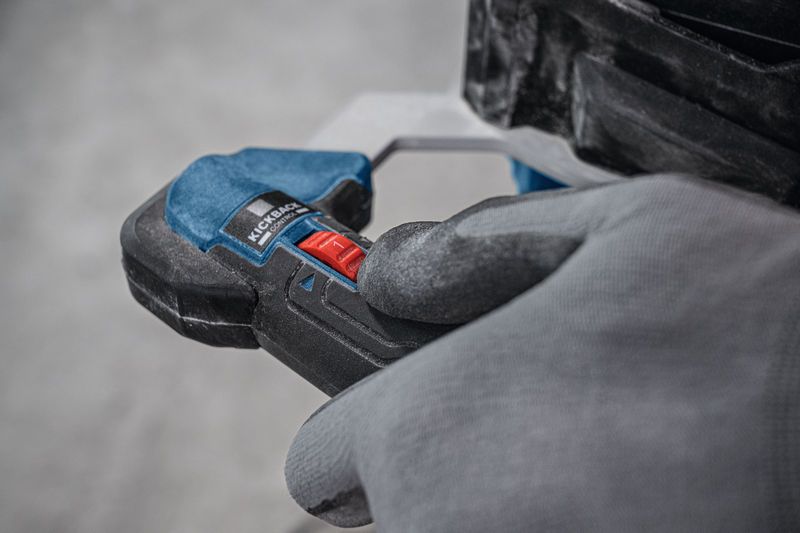 Person wearing safety equipment operates a stirring mechanism with a red control switch.