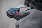 Person wearing safety equipment operates a stirring mechanism with a red control switch.