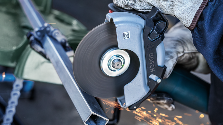 Object #200483038: 3089912_app_web_8 Person wearing safety equipment cuts a metal beam with a circular saw, sparks flying.
