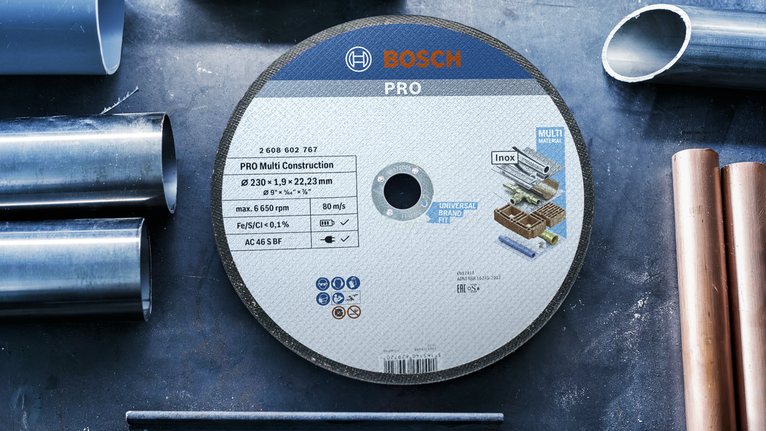 Cutting disc placed on a workbench surrounded by metal pipes.