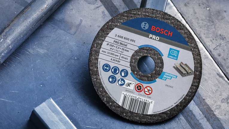Metal cutting disc placed on a metal surface in a workshop setting.