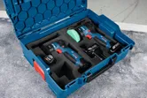 Cordless polisher kit with battery packs and charger organized in a blue carrying case.