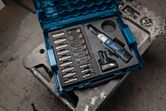 Cordless ratchet wrench kit with sockets and battery organized in a blue carrying case.