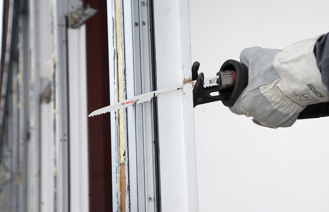 Reciprocating saw blade S 1111 DF A worker wearing safety equipment uses a reciprocating saw to cut a window frame.