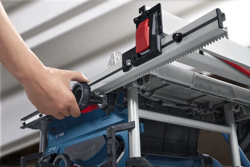 Person adjusts a portable table saw fence using a large black adjustment knob.
