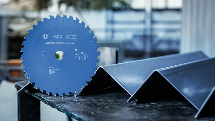 Object #200585155: 7557703_app_web_02 Circular saw blade placed on a table beside angled metal beams.