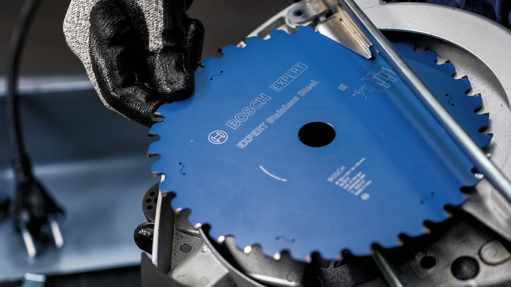 Object #200585156: 7557703_app_web_03 Person wearing safety equipment installs a circular saw blade in a power tool.