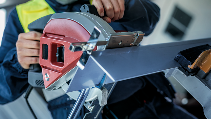 Object #200585161: 7557703_app_web_08 Person wearing safety equipment cuts a metal beam using a circular saw.