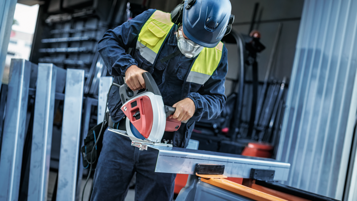 Object #200585162: 7557703_app_web_09 Person wearing safety equipment cuts a metal bar with a circular saw.