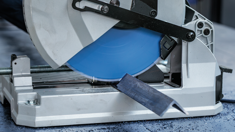EXPERT Steel Circular Saw Blade, 254 x 2.6/2.2 x 25.4 mm, T60 Metal cutoff saw cutting through a steel bar on a workshop floor.