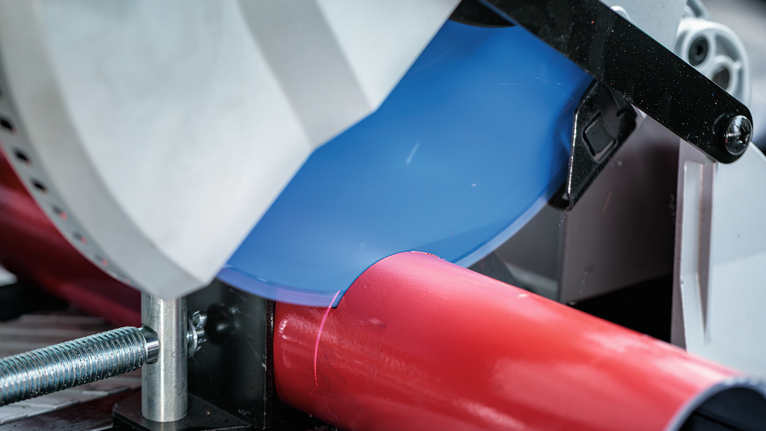 EXPERT Steel Circular Saw Blade, 254 x 2.6/2.2 x 25.4 mm, T60 Circular saw cutting through a red metal pipe in a workshop setting.