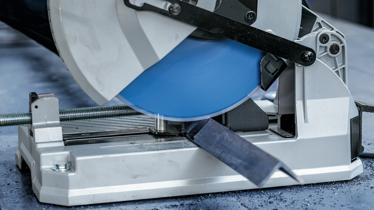 EXPERT Steel Circular Saw Blade, 254 x 2.6/2.2 x 25.4 mm, T60 Metal cutting saw slices through a steel bar on a workshop table.