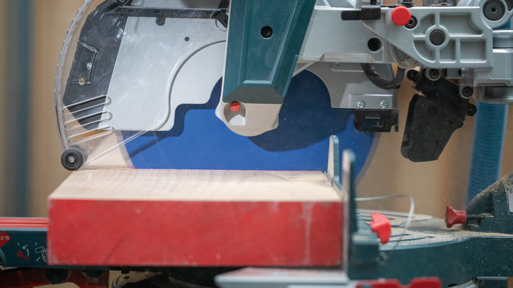 Object #200585322: 7557711_app_web_08 Circular saw cutting a piece of wood on a workbench.