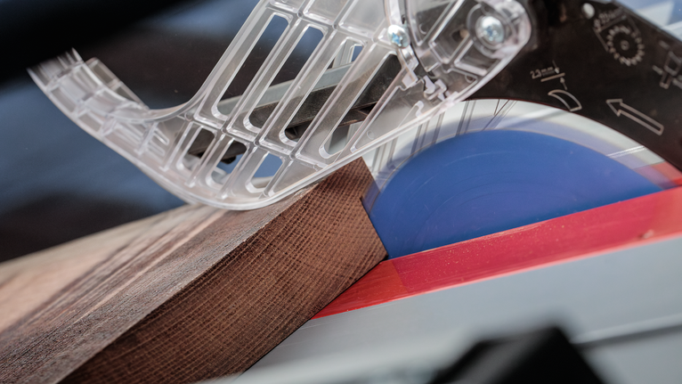 EXPERT Wood Circular Saw Blade, 254 x 2.6/1.8 x 30 mm, T54 Circular saw cutting through a piece of wood under a transparent blade guard.