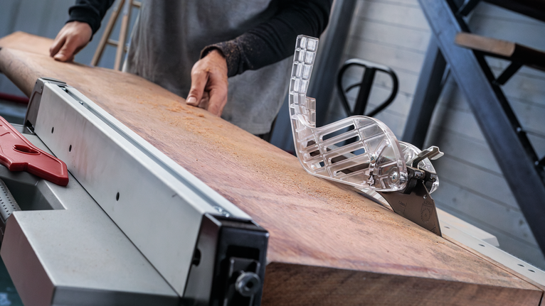 EXPERT Wood Circular Saw Blade, 254 x 2.6/1.8 x 30 mm, T54 Person pushing a large wooden board through a table saw in a workshop.