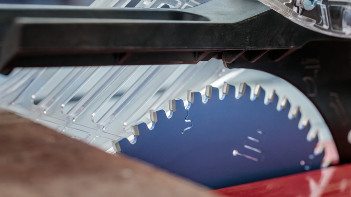 Object #200585345: 7557712_app_web_10 Circular saw blade positioned beneath a transparent safety guard.