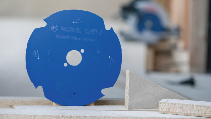 Object #200585525: 7557691_app_web_02 Blue circular saw blade standing upright beside fiber cement boards.