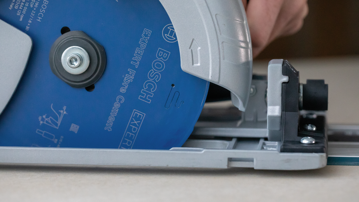 Object #200585527: 7557691_app_web_04 Person guides a circular saw along a track to cut a sheet of material.