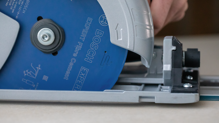 EXPERT Fibre Cement Circular Saw Blade, 165 x 2.2/1.6 x 20 mm, T4 Person guides a circular saw along a track to cut a sheet of material.