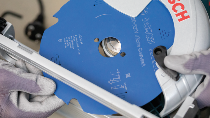 Object #200585528: 7557691_app_web_05 Person wearing safety equipment installs a blue circular saw blade into a power tool.