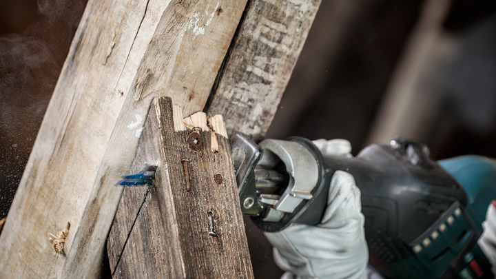 Object #200585876: 7785204_app_web_01 Person wearing safety equipment cuts a wooden beam using a reciprocating saw.