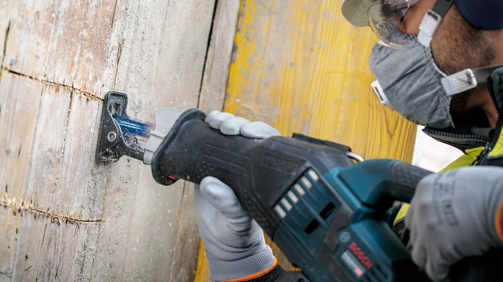 Object #200585879: 7785204_app_web_04 Person wearing safety equipment cuts wooden board with a reciprocating saw.