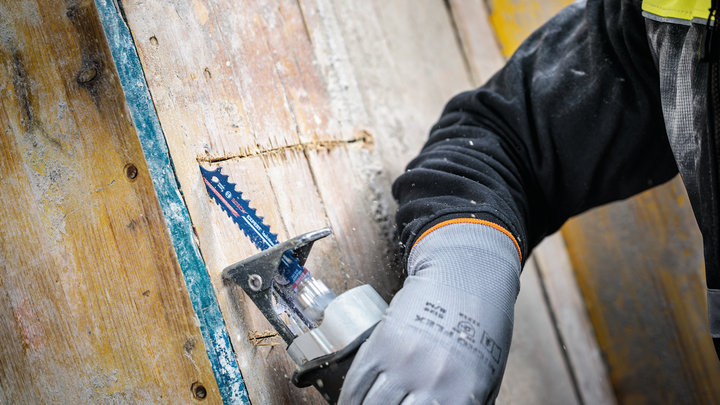 Object #200585884: 7785204_app_web_09 Person wearing safety equipment cuts wood with a reciprocating saw.