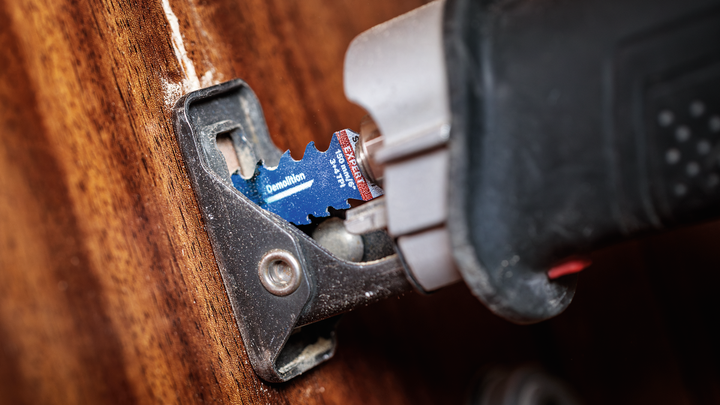 Object #200585887: 7785204_app_web_12 Oscillating multi-tool with a demolition blade cutting through wood.