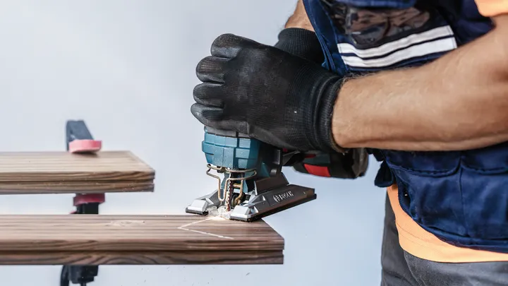 Object #200597813: 2793294_app_web_04 Person wearing safety equipment cuts wood with a jigsaw.