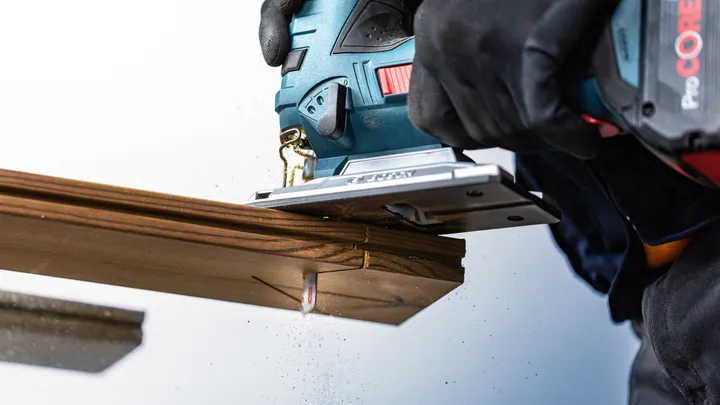 Object #200597814: 2793294_app_web_05 Person wearing safety equipment cuts wood with a jigsaw.