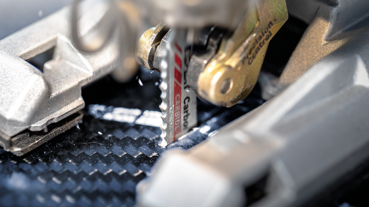 Object #200597834: 2793285_app_web_06 Jigsaw blade cutting through a carbon fiber sheet.