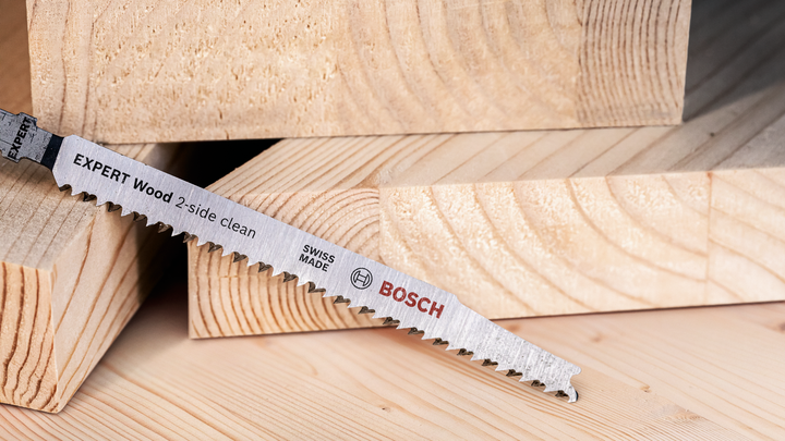 Saw blade resting on stacked cut timber pieces.