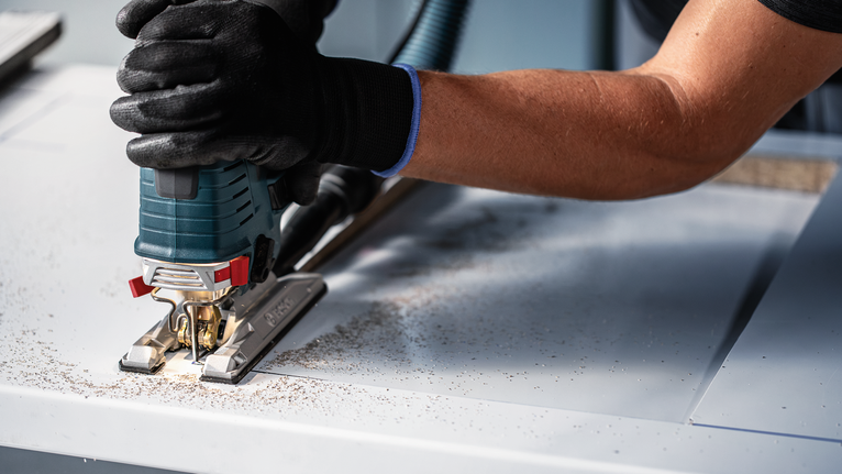 EXPERT Hardwood 2-side clean T308BFP Jigsaw Blade, 3 pcs Person wearing safety equipment cuts wood with a jigsaw.