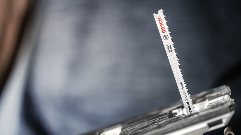 EXPERT Hardwood 2-side clean T308BFP Jigsaw Blade, 3 pcs Close-up of a jigsaw blade installed in a power tool.